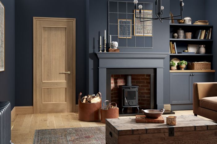 a living room filled with furniture and a fire place in front of a wooden door