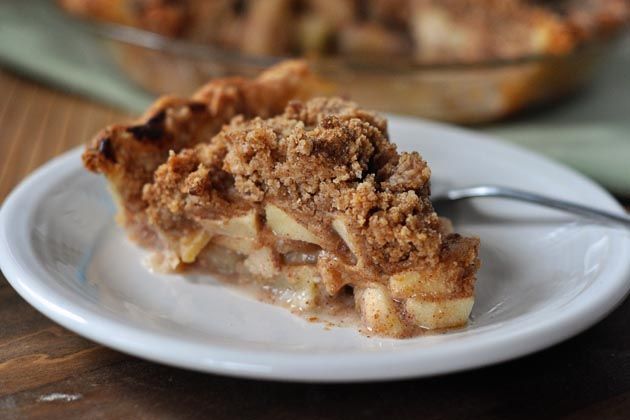 a piece of pie on a plate with a fork next to it and another dish in the background