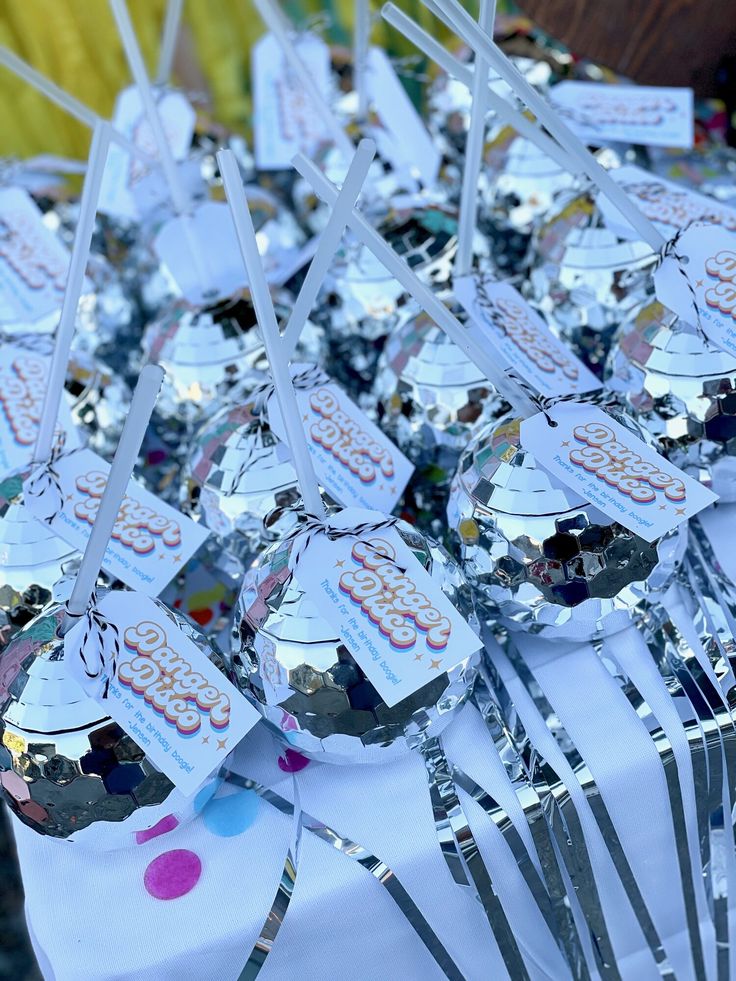 a table topped with lots of silver spoons covered in confetti and candy