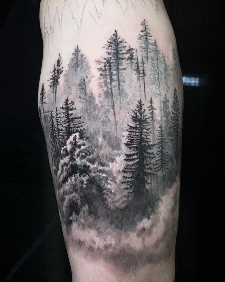 a man's thigh with trees and clouds on it