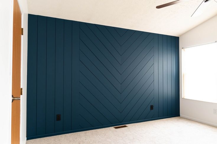 an empty room with blue walls and white carpet