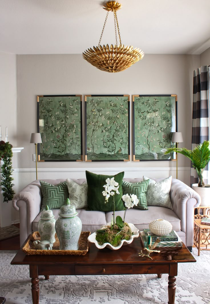 a living room filled with furniture and paintings hanging on the wall above a coffee table