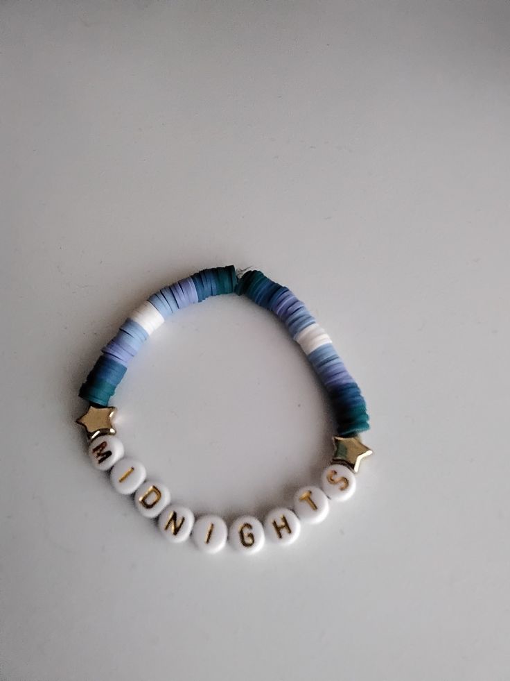 a beaded bracelet with the word midnight written in gold and white letters on it