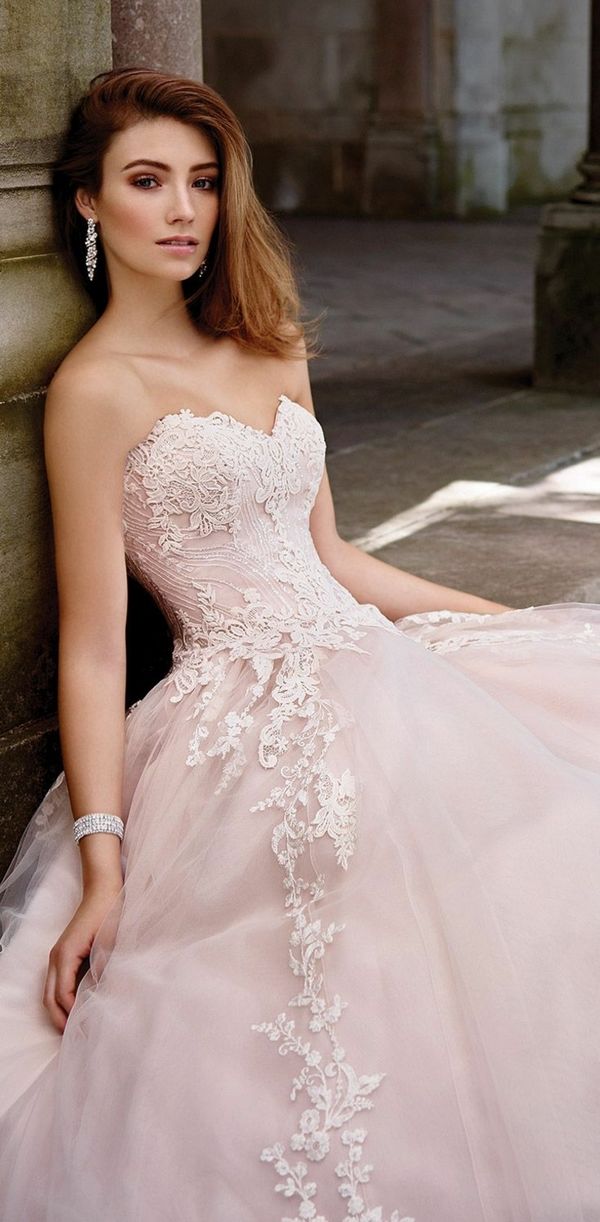 a woman in a wedding dress leaning against a wall