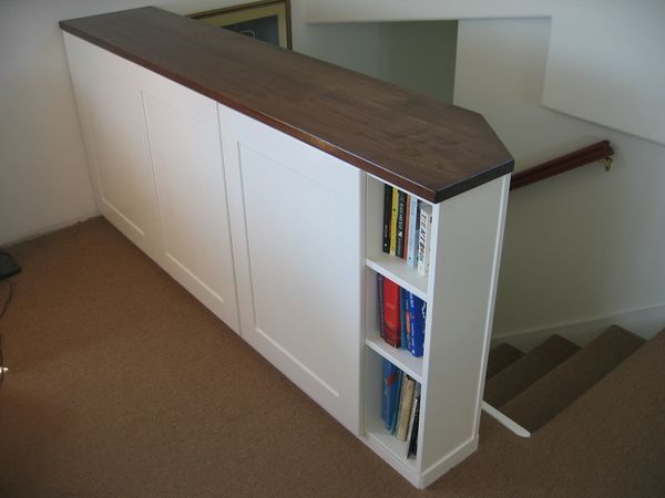 a book shelf with books on it next to stairs