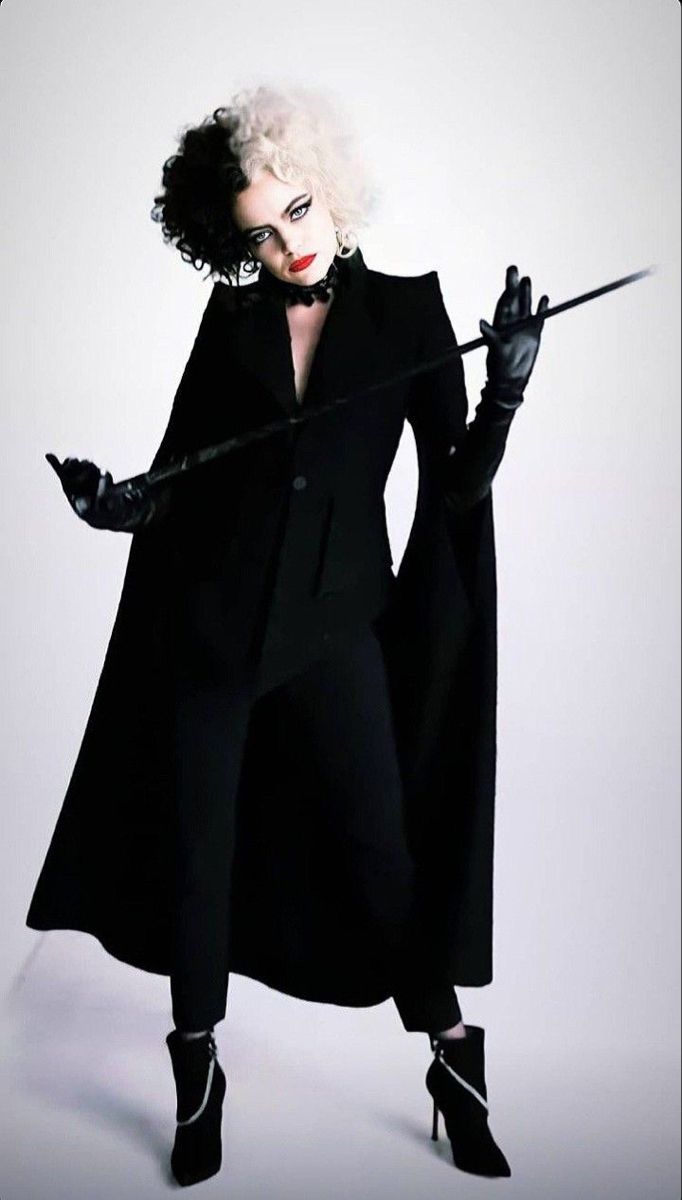 a woman dressed in black holding a wand