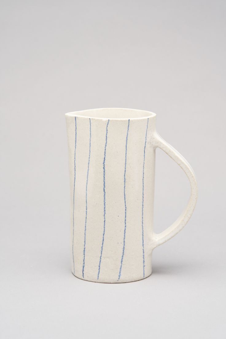 a white coffee cup with blue lines on it