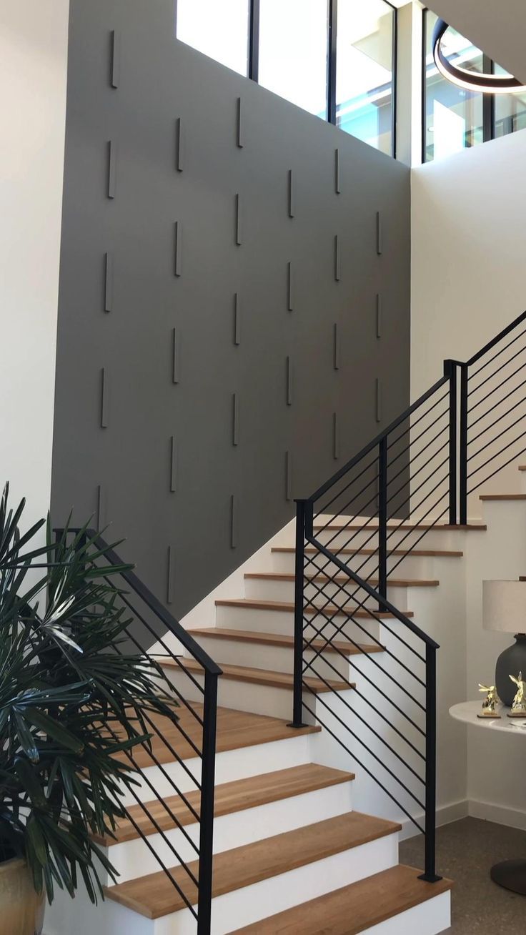 a stair case with metal railings and wooden steps in a modern style home setting