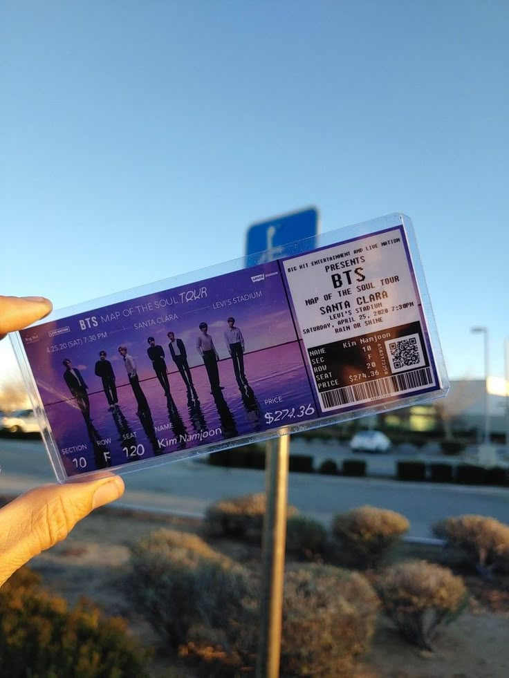 someone is holding up a ticket for the concert