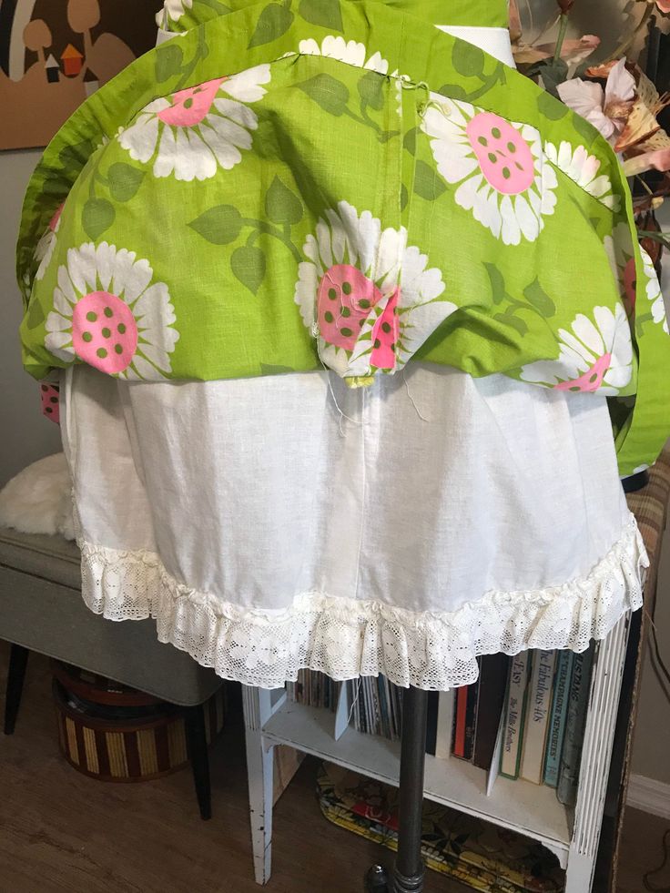 "Cute as can be! Apple green with whimsical flowers in white and neon pink. Attached white cotton and lace petticoat. Two tiny Frey's in fabric at the hem pictured. Easily repaired. Measurements: 26\" waist 42\" free flared hips 70\" circumference at hem 1-3/4\" waistband 7-1/2\" back nylon zipper with two button waist closure 19\" from top of the waistband to hem from the back" Summer Cotton Skirt With Attached Cancan, Green Cotton Ruffled Bottoms, Pink Cotton Skirt With Lace Trim, Vintage Petticoat With Attached Cancan For Spring, Spring Lace Trim Skirt For Garden Party, Spring Green Bottoms With Lace Trim, Spring Garden Party Skirt With Lace Trim, White Lined Skirt For Garden Party, Lace Trim Skirt For Spring Garden Party