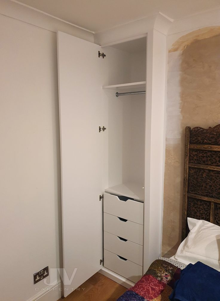 a bedroom with a bed, dresser and closet in the corner on the wall next to it