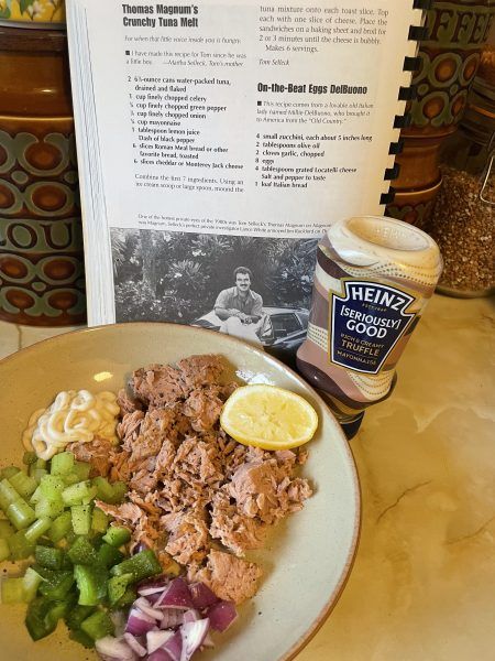 a plate with meat, noodles and vegetables on it next to a book about health