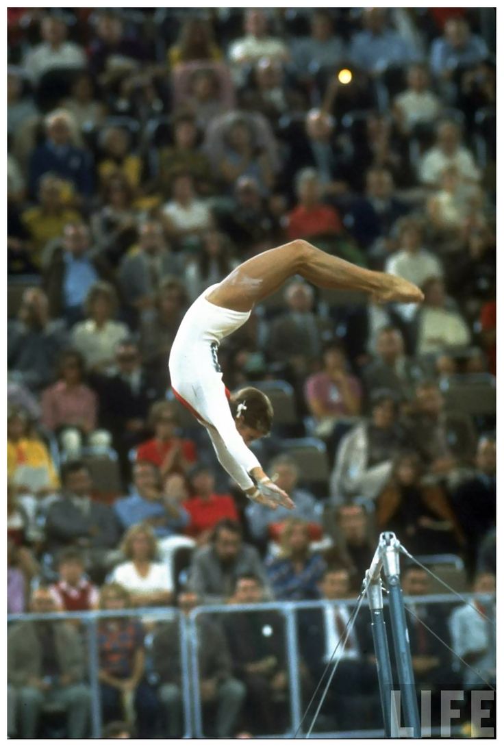 a man on a balance beam in front of an audience