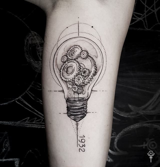 a black and white photo of a light bulb with gears in it on the arm