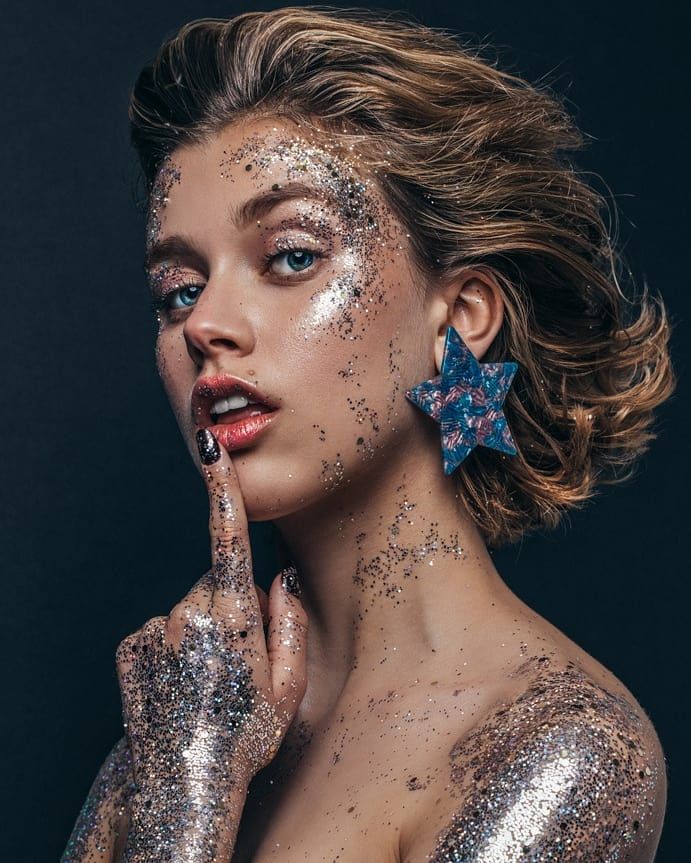 a woman with glitter on her face and hands