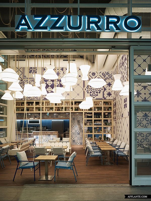 the inside of a restaurant with many tables and chairs in front of an illuminated sign that reads azzurro