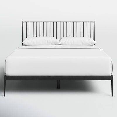 a bed with white sheets and pillows on it