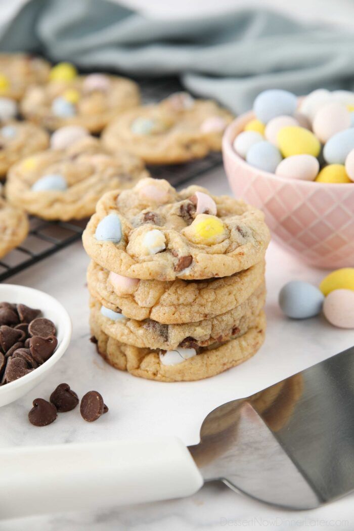 chocolate chip cookies with m & m candy in the middle next to a bowl of easter eggs