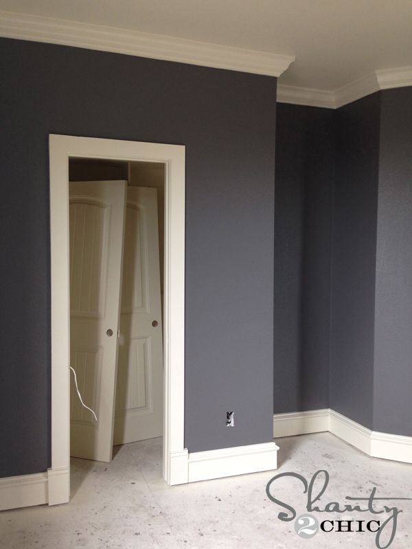 an empty room with gray walls and white trim on the door, carpeted floor