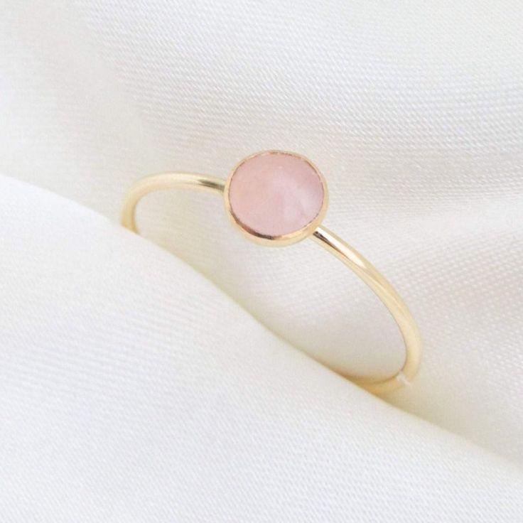 Our delicate Rose Quartz Ring features a pink natural gemstone in a gold filler or sterling silver setting! Rose Quartz is the birthstone for all our October-born babes. Don't know your ring size? Ring Size Guide or Buy Ring Sizer …………………………………. Details: Stone is Natural Rose Quartz, measuring 5mm Available in 14k Gold Filled or Sterling Silver Waterproof and can be worn everyday Size Inclusive and made to order About Your Jewelry If you are not wearing your jewelry it is best to store it in a c Opal Stacking Ring, Yellow Gold Solitaire Ring, Pink Engagement Ring, Timeless Engagement Ring, Precious Stones Rings, June Birthstone Ring, October Birthstone Rings, Dainty Gold Rings, Gold Solitaire Ring