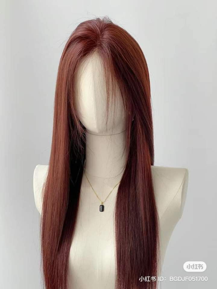 a wig with long red hair on a mannequin head