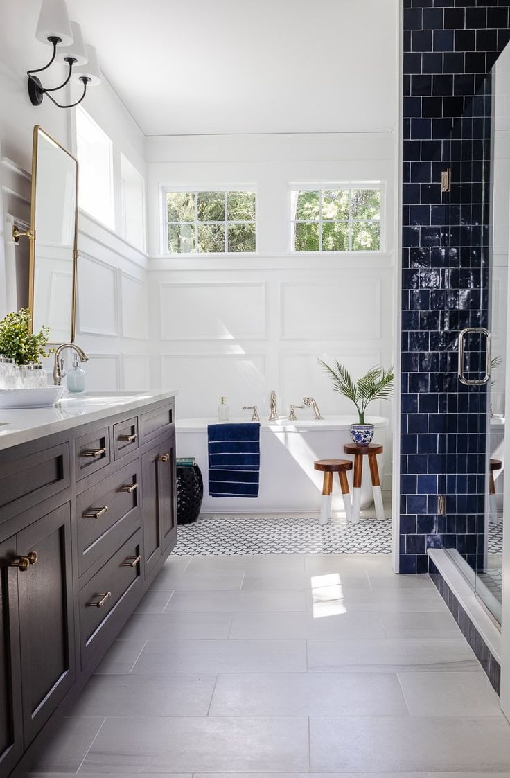 a bathroom with blue and white tiles on the floor, tub, sink and toilet