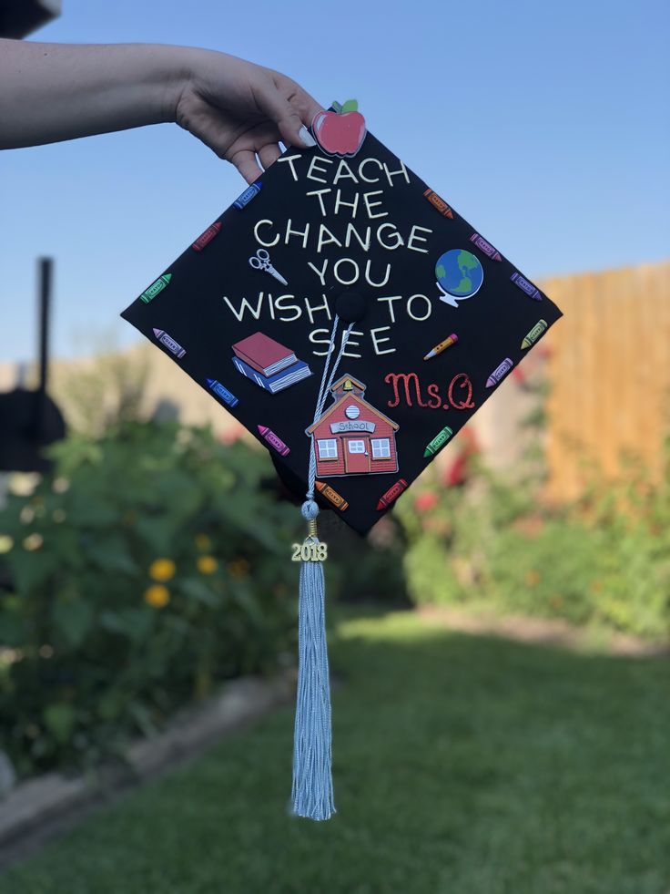 someone is holding up a graduation cap that says teach the change you wish to see