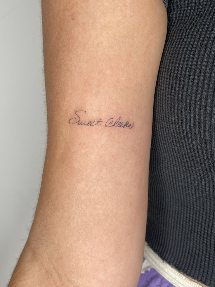 a woman's arm with a small tattoo saying sweet claws on it, in cursive writing