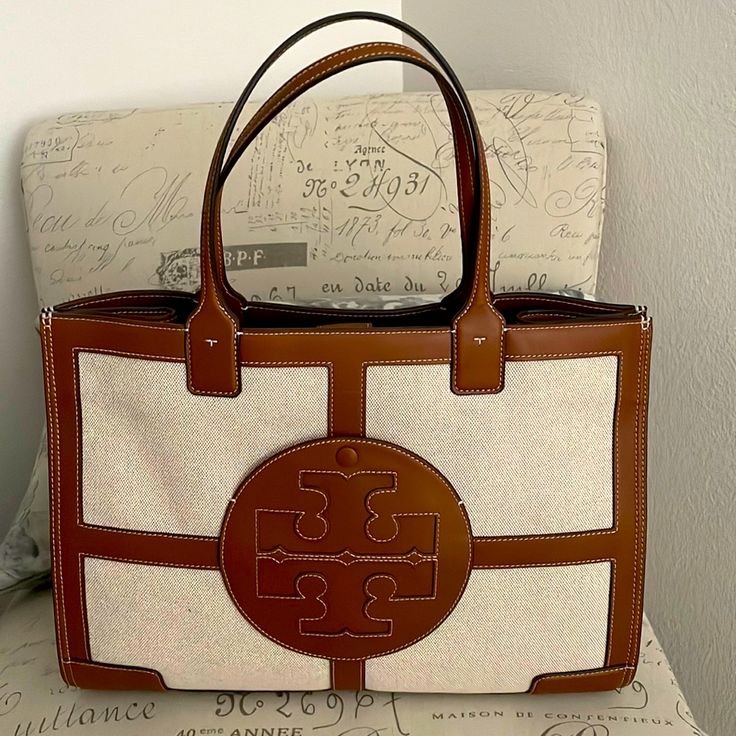 Never Used Tory Burch Leather And Material Tote. Immaculate Condition Tory Burch Handbag, Beige Monogram Canvas Bag With Double Handle, Beige Double Handle Monogram Canvas Bag, Designer Neutral Rectangular Bags, Designer Rectangular Neutral Bags, Beige Monogram Canvas Top Handle Shoulder Bag, Luxury Beige Coated Canvas Shoulder Bag, Beige Monogram Canvas Shoulder Bag With Leather Handles, Designer Beige Shoulder Bag With Handles