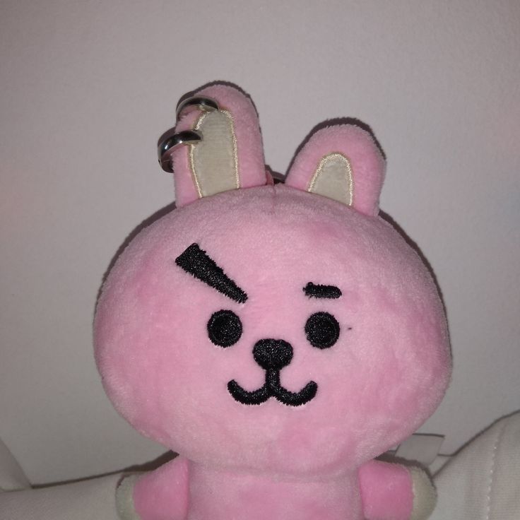 a pink stuffed animal with black ears and eyes