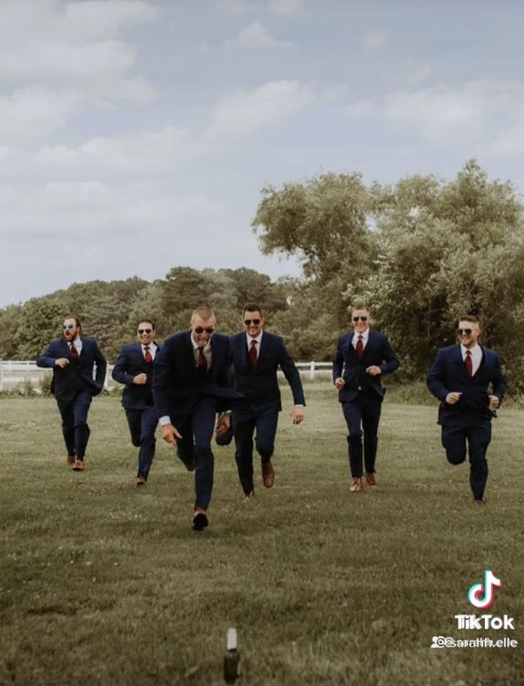 a group of men in suits running across a field