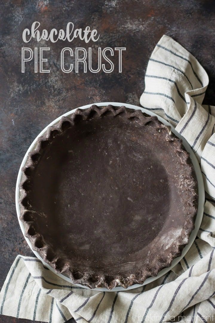 a chocolate pie crust on top of a white and black striped napkin next to it