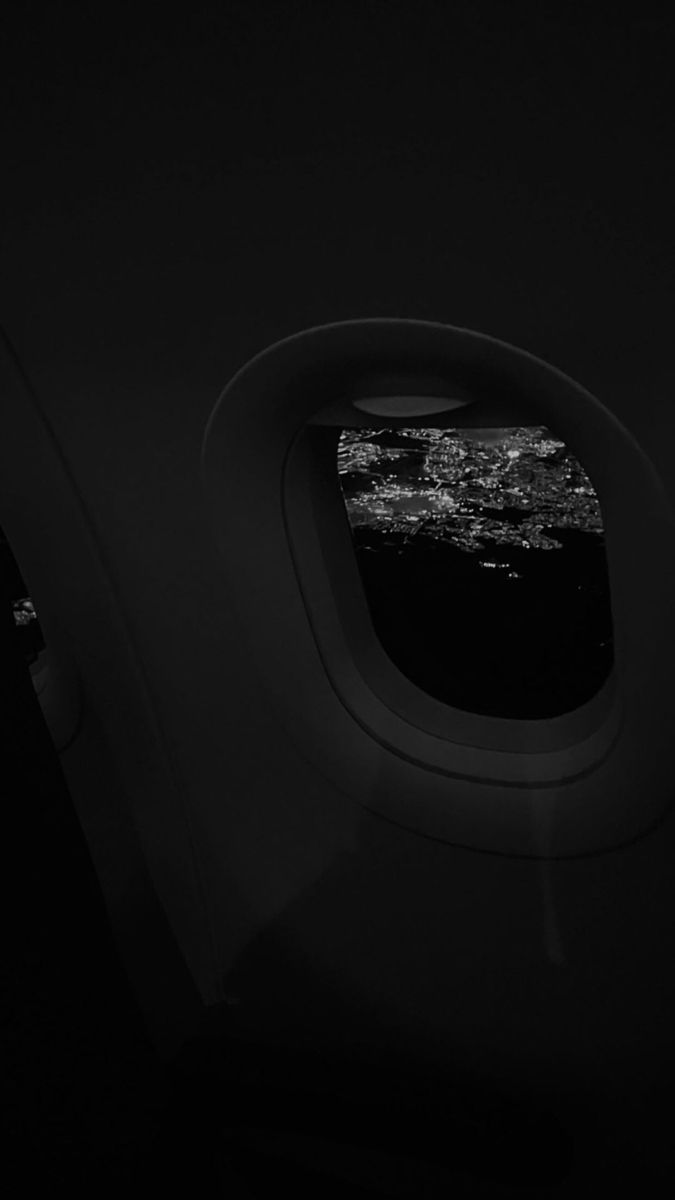 an airplane window looking out at the city lights from inside one of it's windows