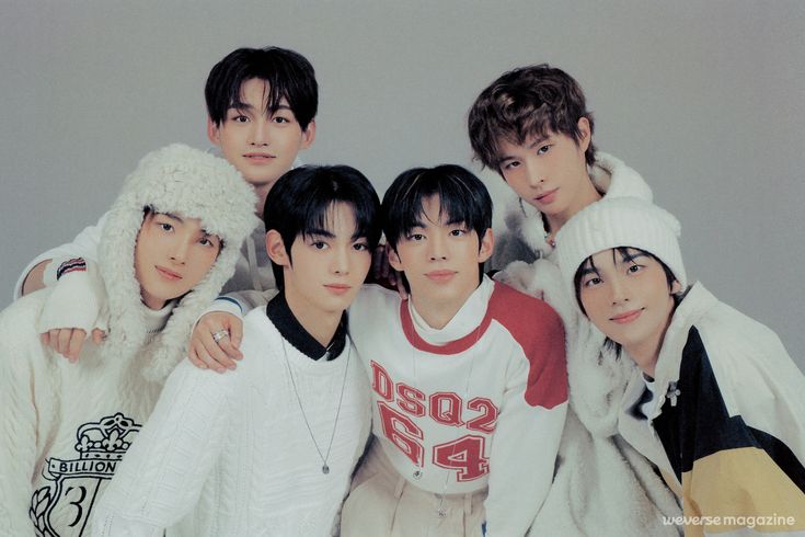 the group of young men are posing together for a photo in winter clothes and fur hats