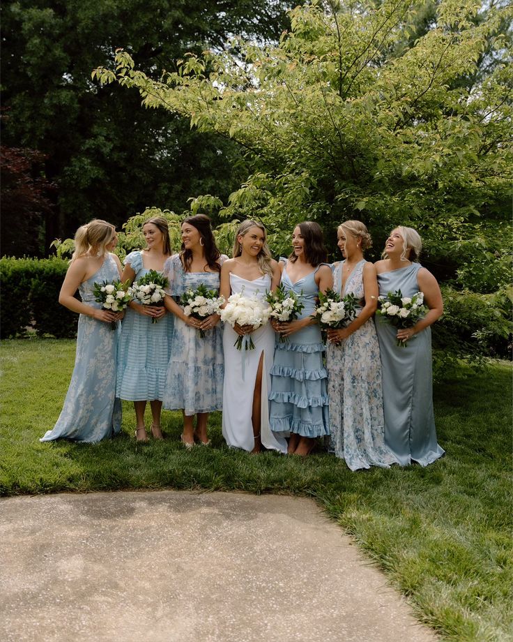 a group of women standing next to each other on top of a lush green field