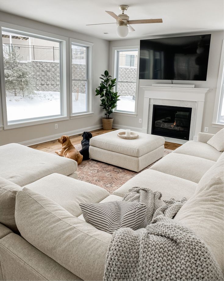 a living room filled with furniture and a flat screen tv mounted on the wall above a fireplace