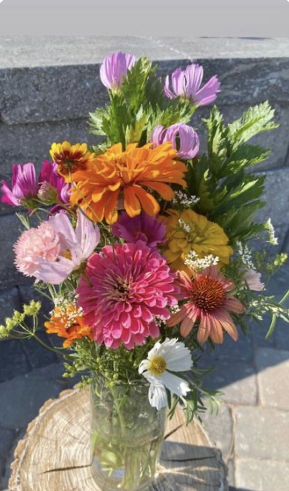 a vase filled with lots of different colored flowers