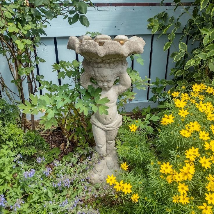 a statue is in the middle of some flowers