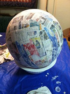 a large paper mache sitting on top of a blue table