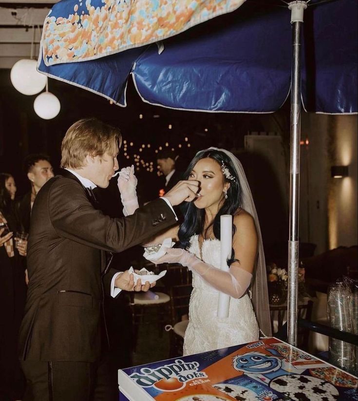 a bride and groom feeding each other cake