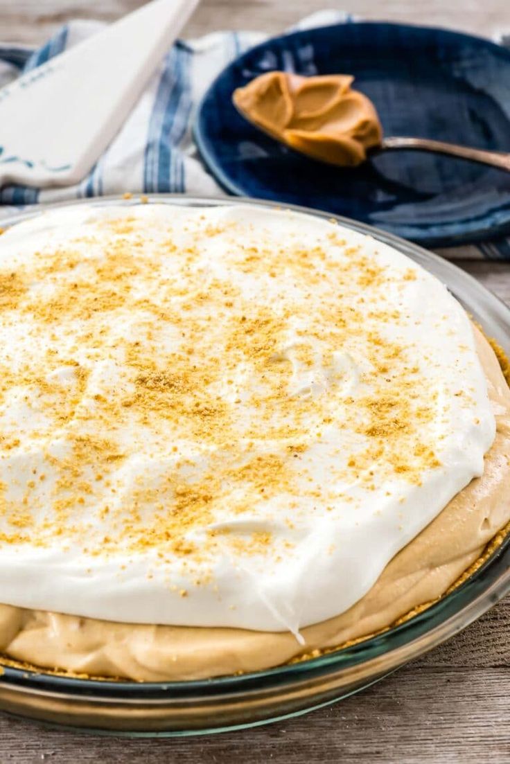 a cake with white frosting and cinnamon sprinkles in a glass pie dish