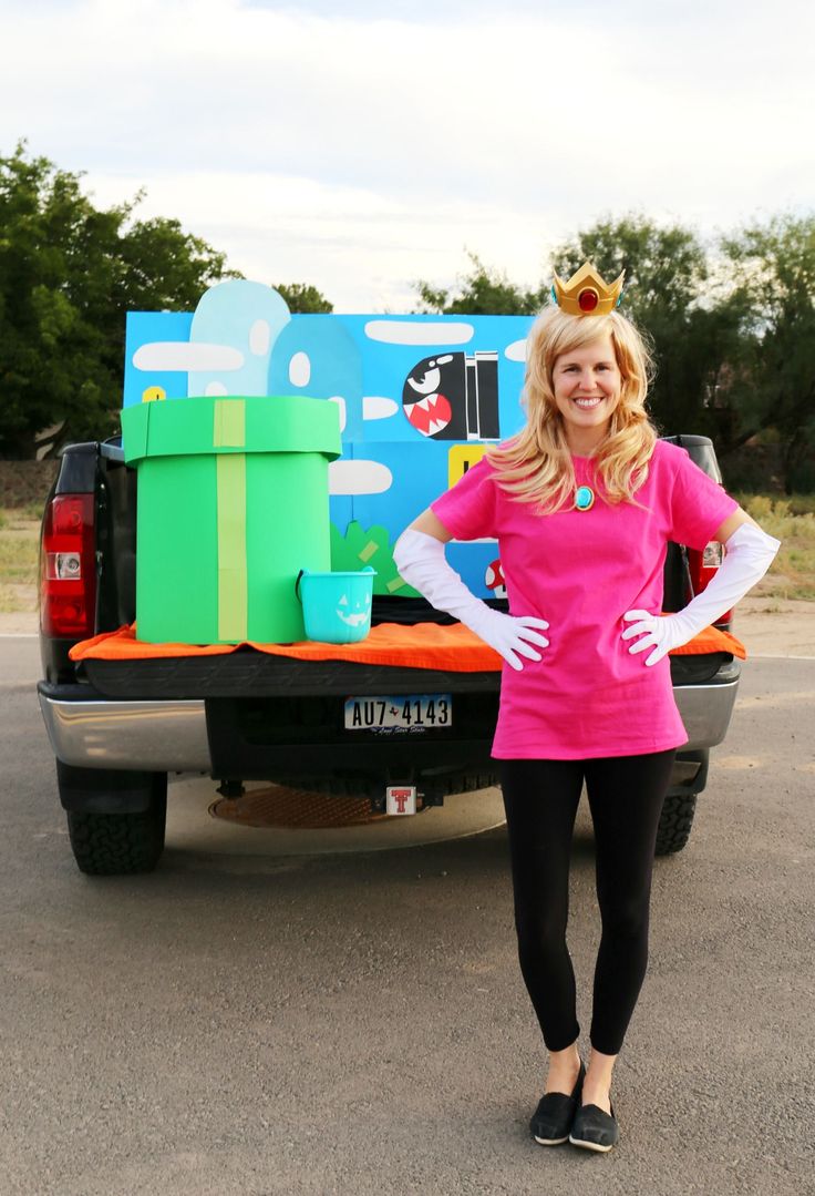 a woman is standing in front of a truck with legos on the back and behind her