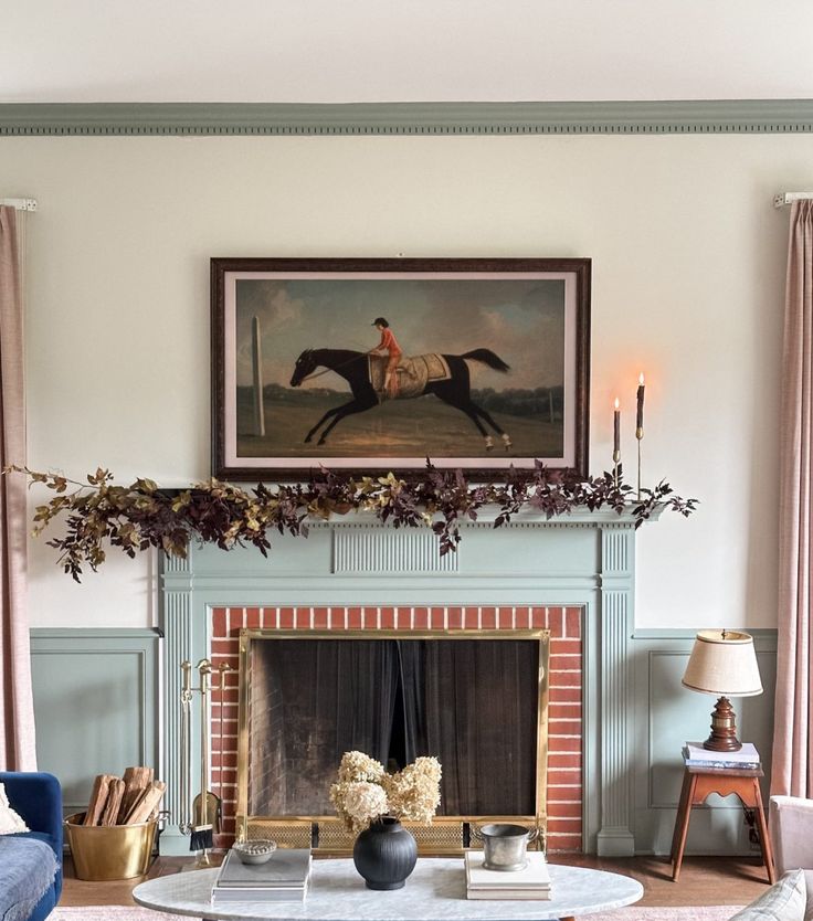 a living room filled with furniture and a painting on the wall above a fire place