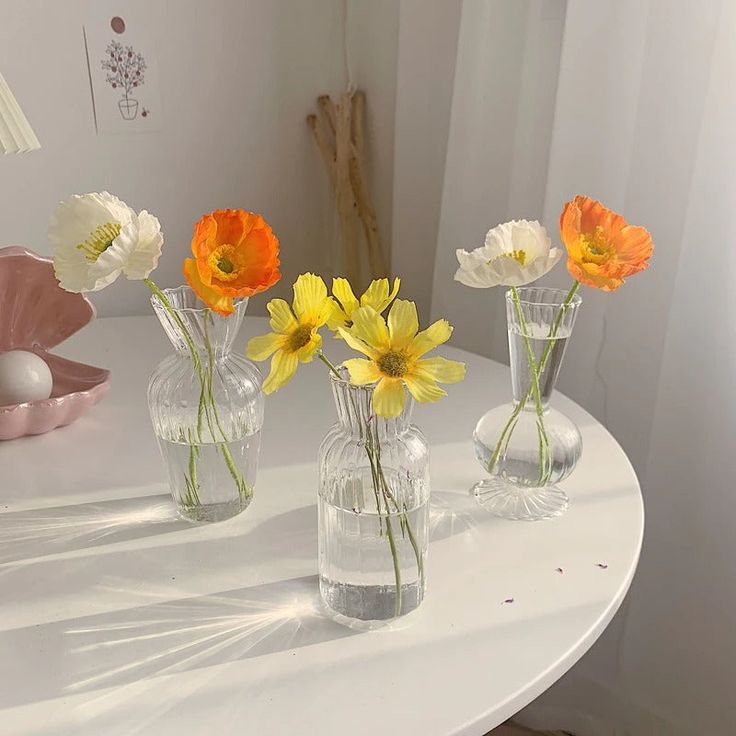 four vases with flowers in them on a table