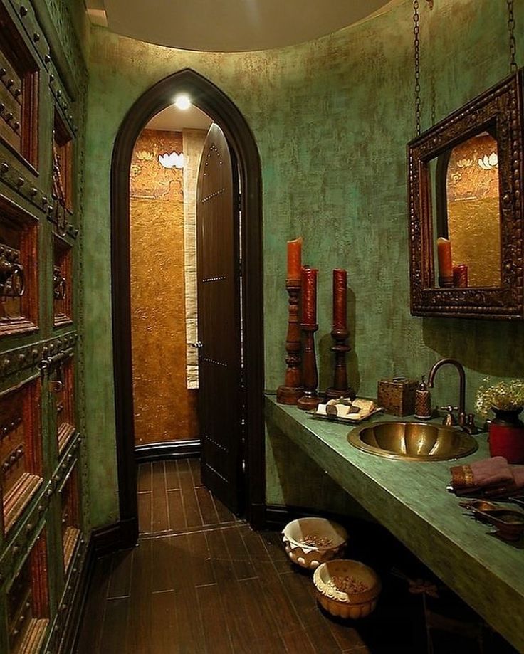 a bathroom with green walls and wooden flooring next to a doorway that leads to another room