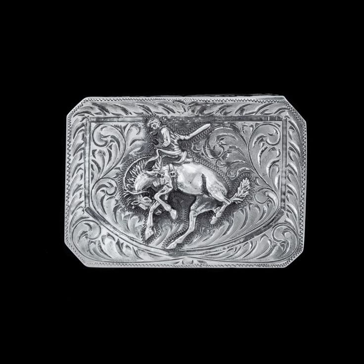 Featuring an immaculate centennial bronc figure set over phenomenal hand engraving, this trophy buckle is an elegant piece fit for any belt. This buckle is a channel style so there is an engraved lip on the top and bottom edges making it three-sided, giving the leather strap a "channel" to pass through, and measures 1 5/8" in height and 2 1/2" across. See our Vogt belt collection to find the perfect match for this buckle. All Vogt sterling items come with the Vogt Family's Unconditional Lifetime Classic Concho Belt Buckles For Rodeo, Western Engraved Belt Buckles For Formal Wear, Antique Engraved Belt Buckles For Formal Wear, Silver Western Belt Buckles For Formal Occasions, Elegant Hand Tooled Belt Buckles For Formal Occasions, Elegant Hand Tooled Belt Buckles For Formal Wear, Elegant Formal Hand-tooled Belt Buckles, Classic Silver Hand-tooled Belt Buckle, Classic Hand Tooled Silver Belt Buckles