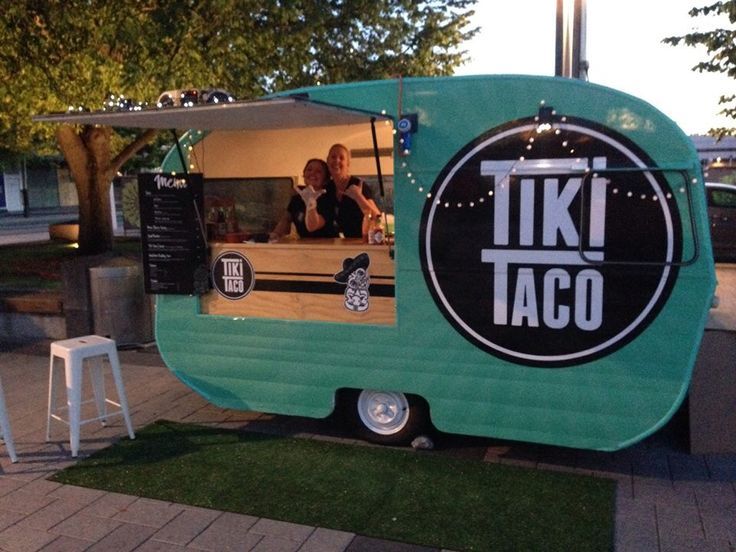 a food truck is parked on the side of the road with people sitting in it