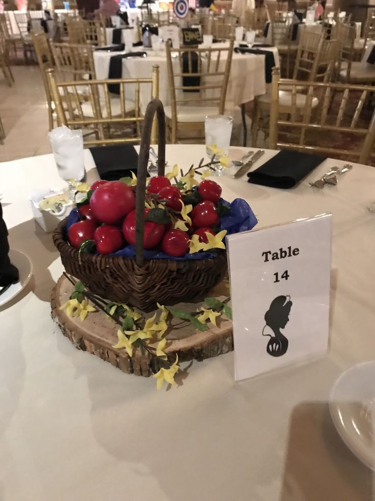 there is a basket with apples in it on top of the table at this wedding reception