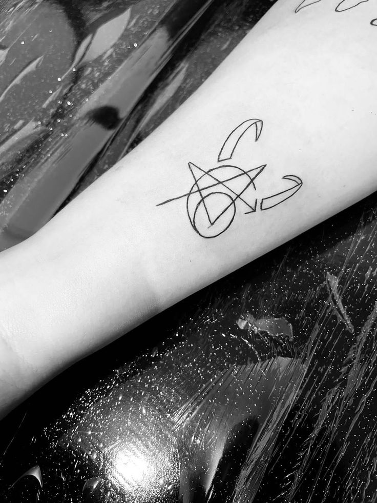 a black and white photo of a person's arm with a tattoo on it