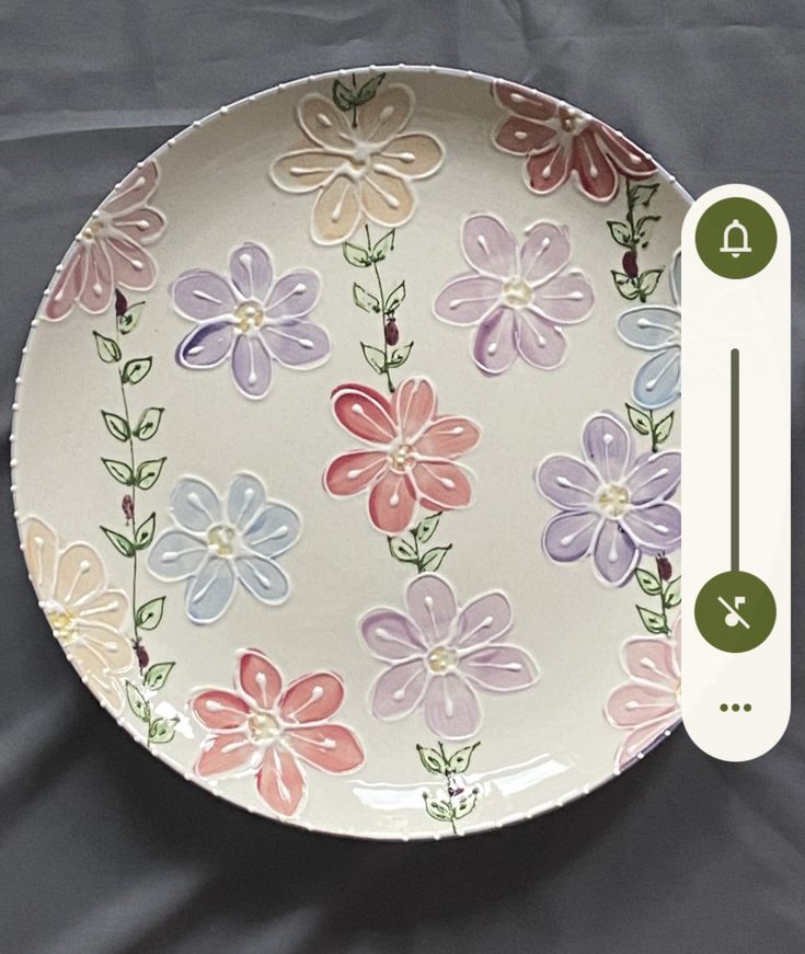 a white plate with flowers on it and a thermometer in front of it